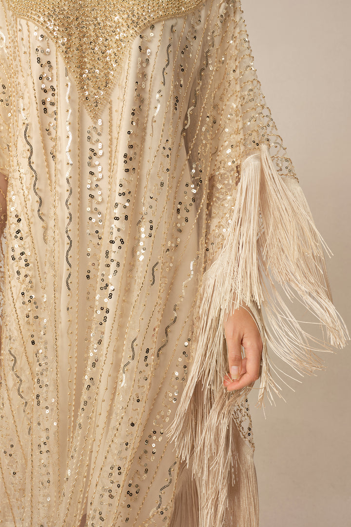 Detail der Pailletten und Fransen am beigen Kleid - KYMA