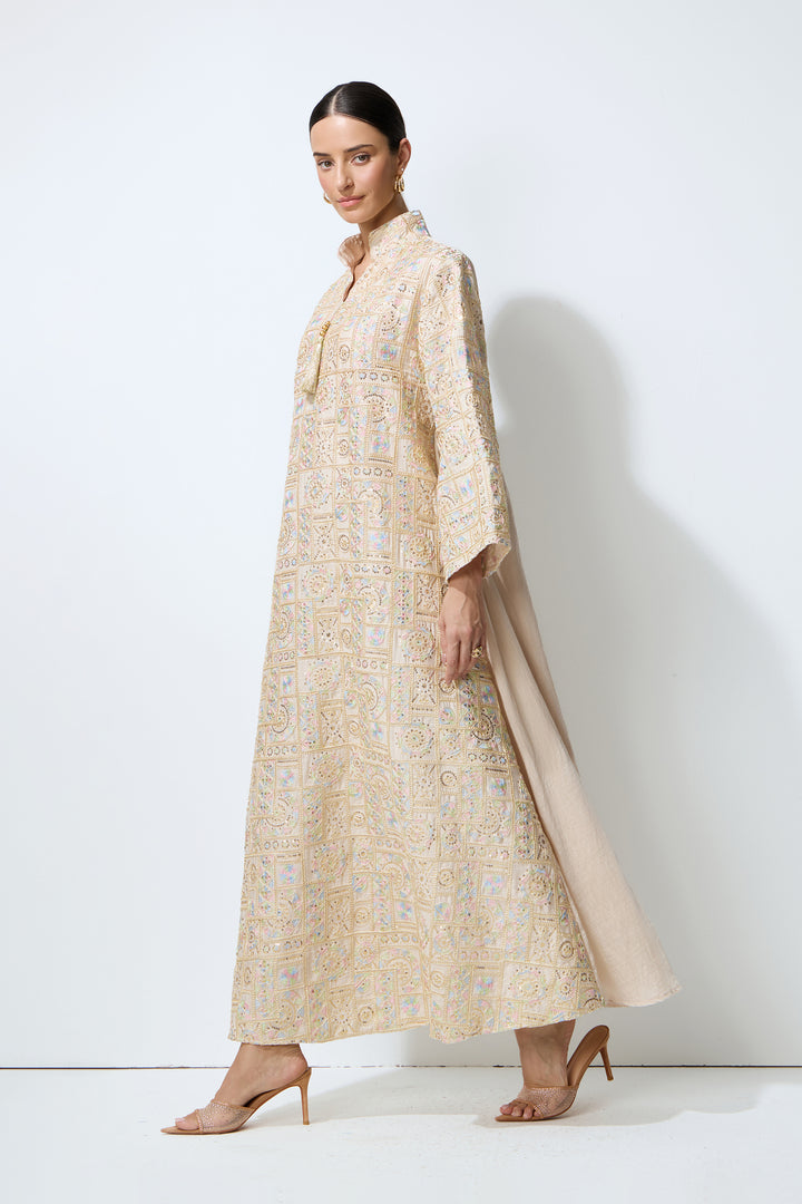 Damen trägt das apricotfarbene Kaftan-Maxikleid mit geometrischer Stickerei – KYMA