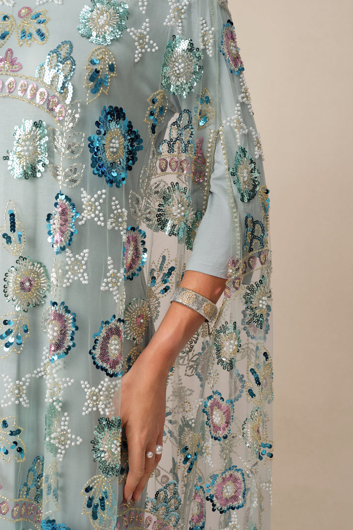 Nahaufnahme der Pailletten auf dem blauen Kleid - KYMA