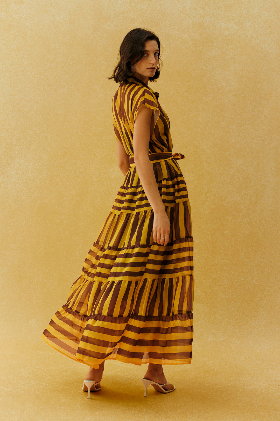 Model trägt das gelbe gestreifte Maxi-Kleid mit Kappenärmeln