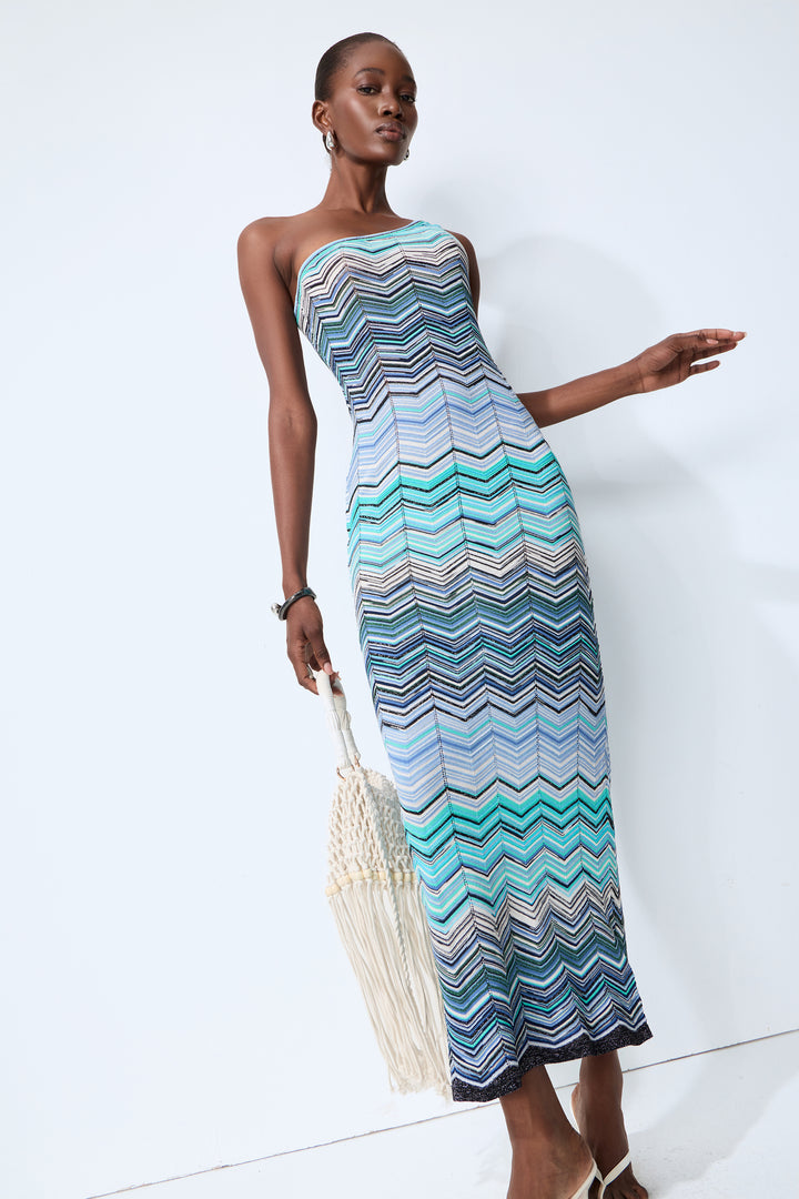 Model trägt das blaue One-Shoulder Maxikleid am Strand - KYMA