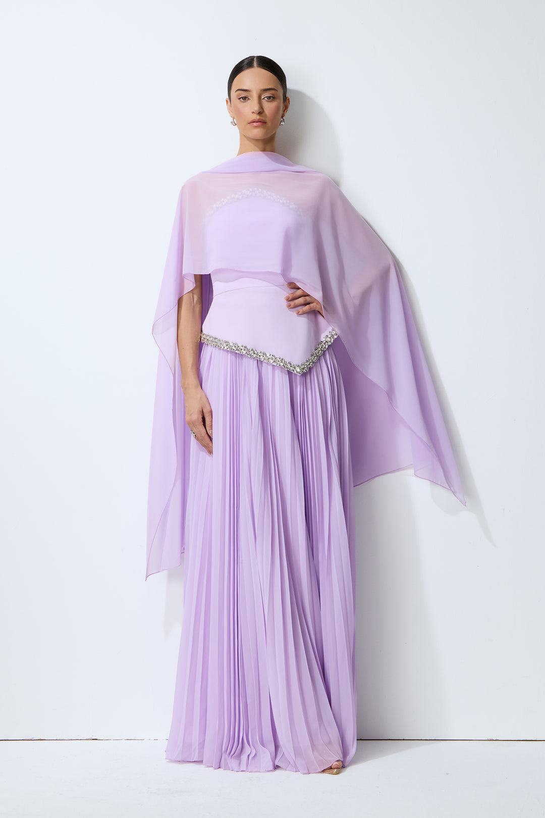 Lila trägerloses Falten-Set mit Cape, das eine Frau in einem eleganten Ambiente präsentiert