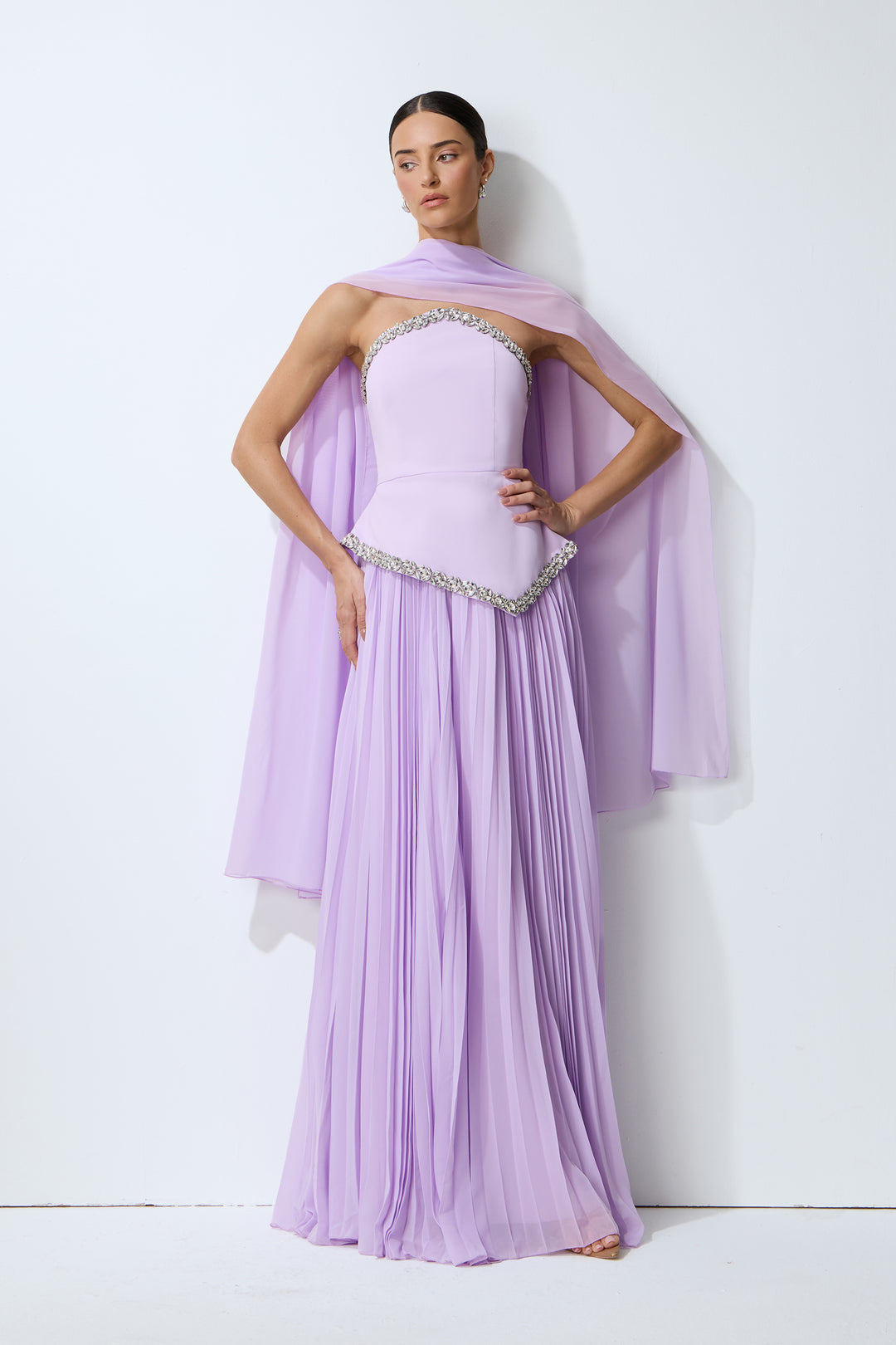 Das lila Set mit Cape, das auf einem Kleiderbügel hängt