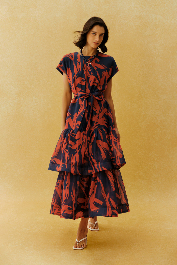 Model trägt das rote Maxikleid mit Blattprint und Bindegürtel - KYMA