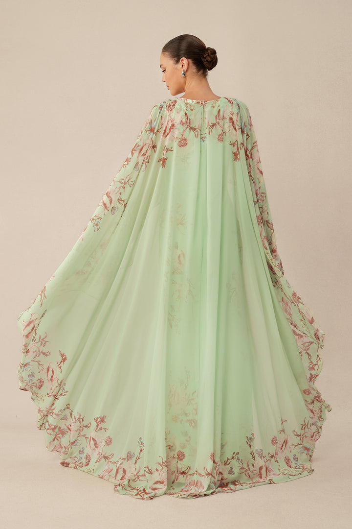 Model im mintgrünen Maxikleid mit Cape