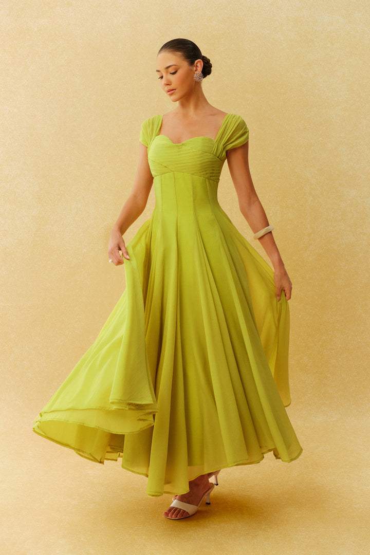 Model trägt das grüne Maxi-Kleid bei einer Gartenparty - KYMA