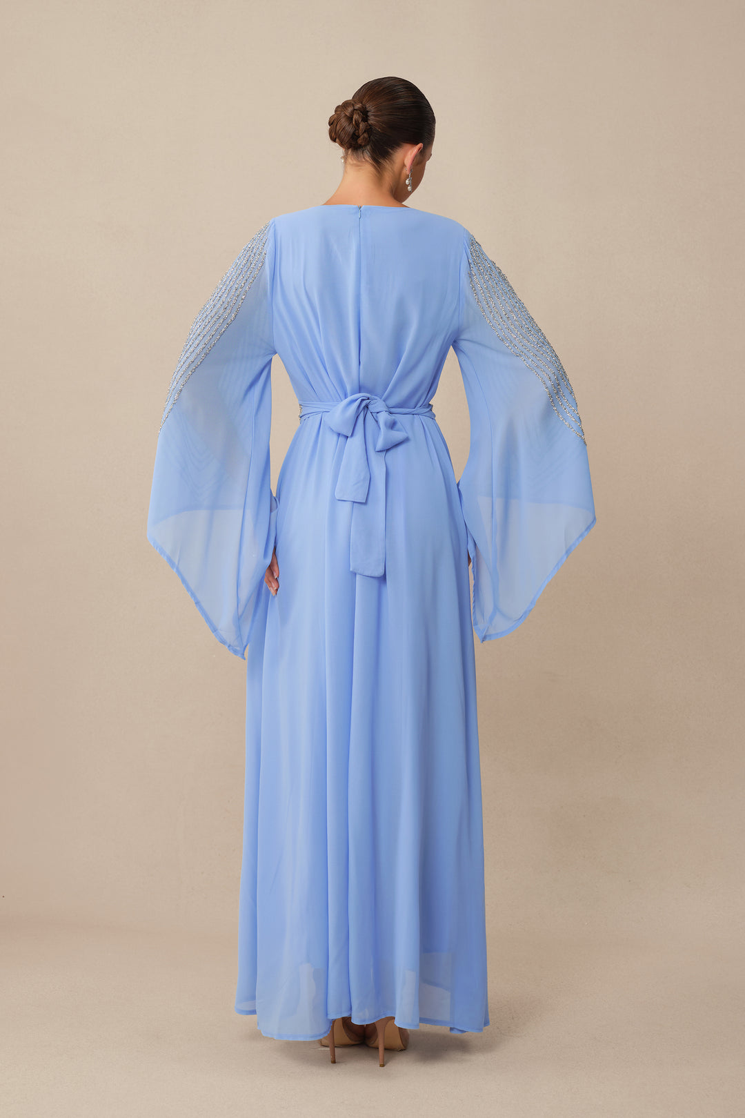Model trägt das blau-funkelnde Maxikleid - KYMA